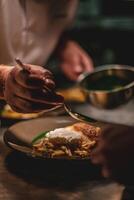 chef in a restaurant preparing and decorating food, delicious dish photo