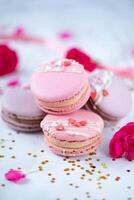 Macaroons with rose petals and confetti on white background photo