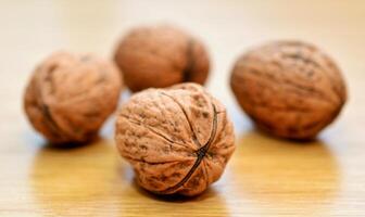 Three walnuts on a wooden table. Shallow depth of field. photo