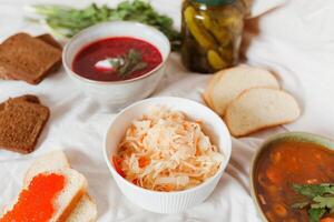 Sauerkraut with red caviar and pickled cucumbers photo