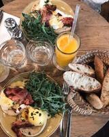 Eggs benedict with arugula and bacon on a wooden table photo