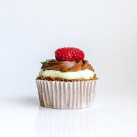 Cupcake with cream and raspberries on a white background photo