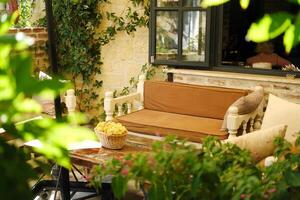 acogedor terraza de un verano café con Clásico banco foto