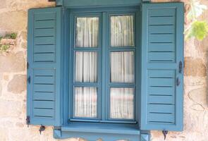 Clásico verde azulado ventana persianas en Roca pueblo casa foto