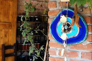 Blue Evil Eye Amulet Hanging on Brick Wall photo