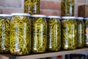 Pickled green beans in glass jars photo