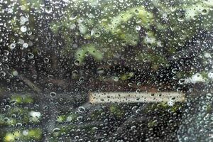 Close-up view of background texture, many rain drops outside the rear window of a car. photo