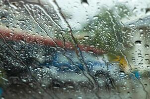 Close-up background view of many rain drops flowing outside the front windshield. photo