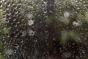 Close-up view of background texture, many rain drops outside the rear window of a car. photo