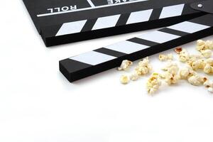 Clapperboard or movie slate black color with popcorn on white background. Cinema industry, video production and film concept. photo