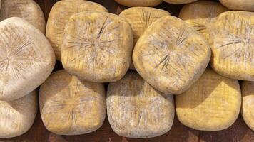 Artisanal Cheese Wheels Stacked at a Rustic Market Stall photo