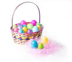 vistoso Pascua de Resurrección huevos en multi color Pascua de Resurrección cesta y en un cama de rosado césped foto