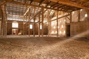 iluminado por el sol vigas en un vacío, polvoriento casa de Campo con Envejecido de madera estructura foto
