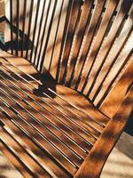 Solid wood bench. Antique wooden bench to sit on. Photo of an old, worn wooden seat. Sunlight reflected on wood