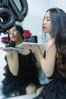 Beautiful woman wearing a black dress and chocolate cake in the concept of birthday photo