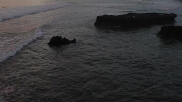 Flug Über Surfer Surfen Ozean Wellen beim Sonnenuntergang. tolle Sonnenuntergang Antenne Ozean Sicht. oben Nieder Schuss von texturiert Ozean dann offenbart Surfer im das Sonnenuntergang video