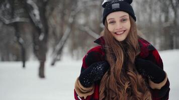 vinter- ung kvinna porträtt. skönhet glad modell flicka skrattande och har roligt i vinter- parkera. skön ung kvinna utomhus, njuter natur, vintertid video