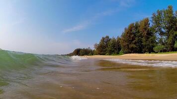 lento movimento cenas do uma turquesa onda rolando para a arenoso costa do uma tropical ilha. embaixo da agua Câmera mergulho debaixo a mar onda video