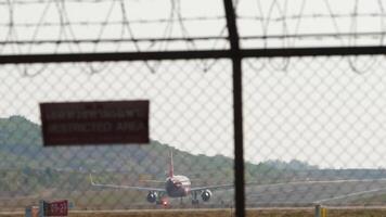 Jet vliegtuig nemen uit Bij phuket luchthaven. airpalne vertrekkend. visie door de luchthaven hek video