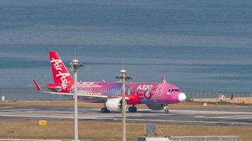 PHUKET, THAILAND - FEBRUARY 20, 2023. Airbus A320, 9M-NEO of AirAsia , A320neo Livery taxiing to the runway for takeoff at Phuket airport. Flight departure. Sea coast near the airfield video