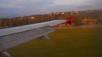 Airplane landing at sunset. First person view of an airplane wing from a window. Touching runway and braking, spoilers up video