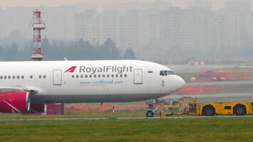 Moscú, ruso federación - julio 30, 2021. tractor tracción boeing 767, vp-bre de real vuelo a sheremetyevo aeropuerto, lado vista. avión en el aeródromo video