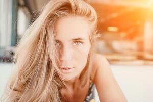 Happy woman portrait in cafe. Boho chic fashion style. Outdoor photo of young happy woman with long hair, sunny weather outdoors sitting in modern cafe.