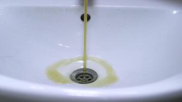 Dirty water flows from the tap. Yellow and brown tap water flows into the sink. Pollution of drinking resources. video