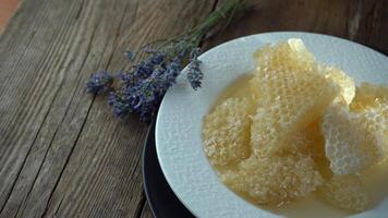 Honig und Waben auf ein Weiß Platte. Süss Essen im ein Schüssel auf das Tisch. ein Produkt von Bienenzucht video