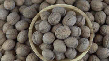 Walnut in shell. Background view from above. Healthy food bowl top view. video