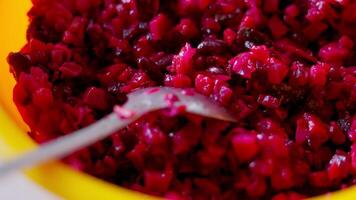 chopped red beet salad with spoon in a plastic bowl video