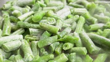 frying green beans on skillet, full-frame closeup view with selective focus video