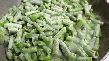 frying green beans on skillet, full-frame closeup view with selective focus video