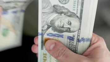 Caucasian hands counting a stack of hundred us dollar banknotes video