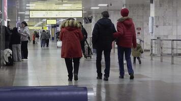 passagiers voorbijgaan door in een hal in de buurt ontvangst bureaus in manas luchthaven video