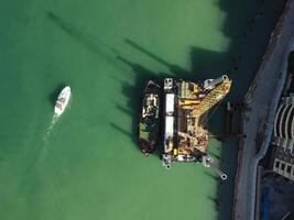 Floating crane dredging barges working on the construction of a marina. Aerial top view photo