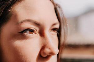 De las mujeres ojos bandera. cerca arriba retrato de contento joven caucásico mujer con pecas a puesta de sol tiempo. linda mujer retrato. foto