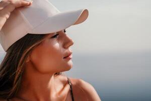 Woman travel sea. Happy tourist taking picture outdoors for memories. Woman traveler looks at the edge of the cliff on the sea bay of mountains, sharing travel adventure journey photo