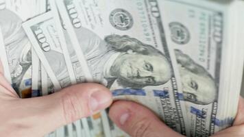 Caucasian hands counting a stack of hundred us dollar banknotes video