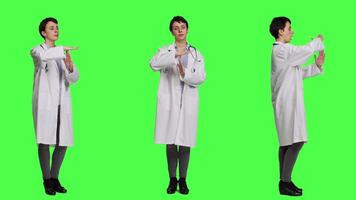 Woman physician doing timeout gesture against greenscreen backdrop, asking for a work break after multiple examinations. Doctor showing pause or stop symbol, feeling tired. Camera A. video