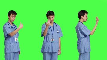 Medical assistant asking a person to come over closer against greenscreen backdrop, inviting patient to approach. Nurse in scrubs calling someone at checkup examination, young surgeon. Camera B. video