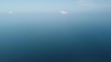 Aerial view from above on calm azure sea and volcanic rocky shores. Small waves on water surface in motion blur. Nature summer ocean sea beach background. Nobody. Holiday, vacation and travel concept video