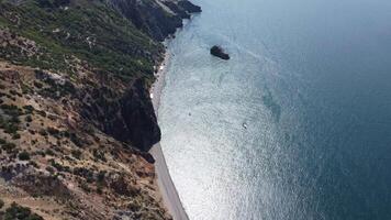 Aerial view from above on calm azure sea and volcanic rocky shores. Small waves on water surface in motion blur. Nature summer ocean sea beach background. Nobody. Holiday, vacation and travel concept video