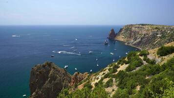 antenne panoramisch visie van zeegezicht met kristal Doorzichtig azuur zee en rotsachtig oevers. jachten in een mooi lagune Aan backdrop van rotsen. de concept van een ideaal bestemming voor zomer reizen en vakantie. video