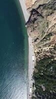 aereo Visualizza a partire dal sopra su calma azzurro mare e vulcanico roccioso sponde. piccolo onde su acqua superficie nel movimento sfocatura. natura estate oceano mare spiaggia sfondo. nessuno. vacanza, vacanza e viaggio concetto video