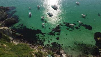 Antenne Panorama- Aussicht von Seelandschaft mit Kristall klar azurblau Meer und felsig Ufer. Yachten im ein schön Lagune auf Hintergrund von Felsen. das Konzept von ein Ideal Ziel zum Sommer- Reise und Urlaub. video