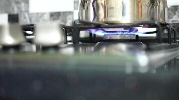 Unrecognizable woman hand turning on stove switch, lighting kitchen burner of gas stove indoors. Stove burner igniting into blue cooking flame. Natural gas inflammation. Close up, slow motion. video