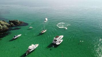 Aerial panoramic view of seascape with crystal clear azure sea and rocky shores. Yachts in a beautiful lagoon on backdrop of rocks. The concept of an ideal destination for summer travel and vacation. video