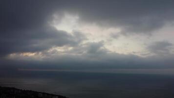 aéreo panorâmico Visão do lindo pôr do sol acima calma azul mar e vulcânico rochoso margens. Sol brilho, pequeno ondas em a água superfície. horizonte. ninguém. não pessoas. Nunca termina beleza do natureza video