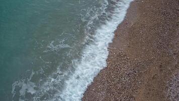 aereo panoramico Visualizza di bellissimo tramonto sopra calma azzurro mare e vulcanico roccioso sponde. sole bagliore, piccolo onde su il acqua superficie. orizzonte. nessuno. no le persone. infinito bellezza di natura video